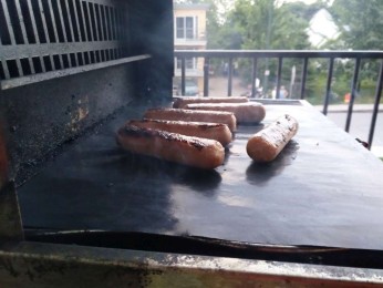 Sausages grilling on Cookina grilling sheet