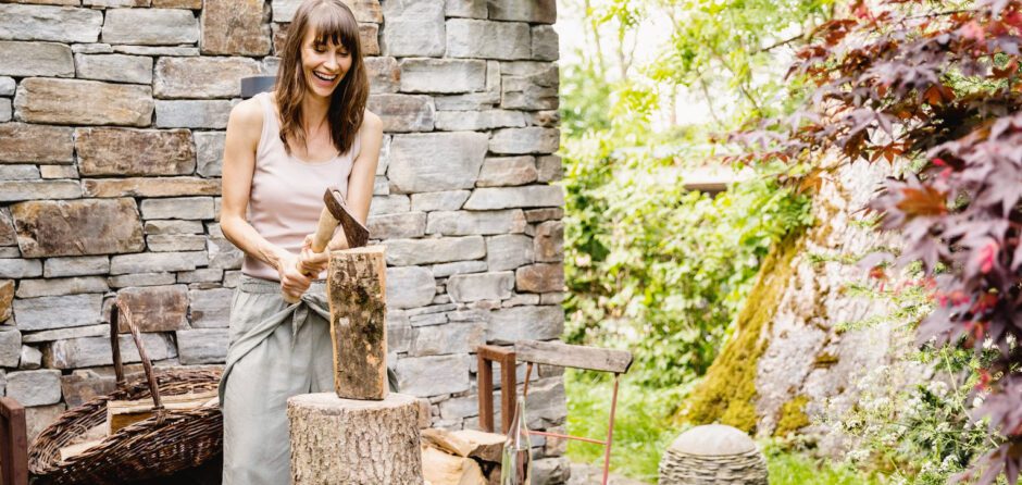 To Do List Before Lighting Your First Fire Of The Season- a woman cut her wood for the winter