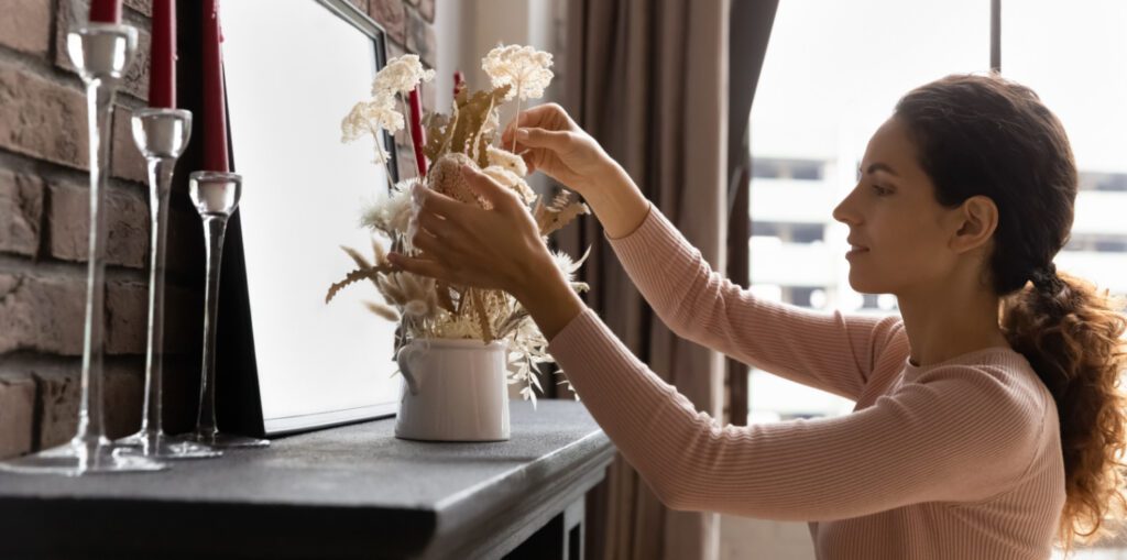 A lady decorating her fireplace for summer
