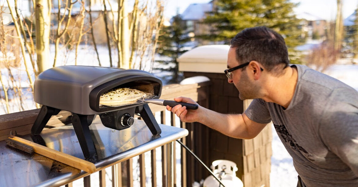 A man is doing a pizza in the pizza oven Pizzero® by Ambiance®