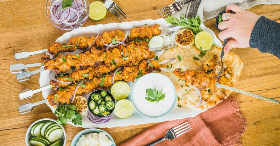 A plate of chicken skewers with naan bread